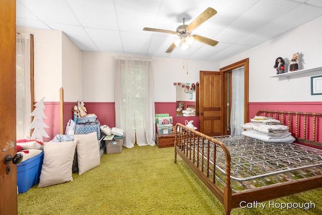 carpeted bedroom featuring a paneled ceiling and ceiling fan