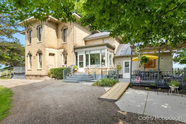 exterior space featuring a wooden deck and a patio