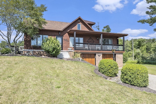 back of property with a garage, a lawn, and a balcony