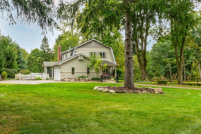 18760 Valencia St, Northville, MI 48168 - rear view of property with driveway, a chimney, fence, and a yard