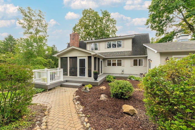 18760 Valencia St, Northville, MI 48168 - back of property with a sunroom, a shingled roof, a chimney, and a wooden deck