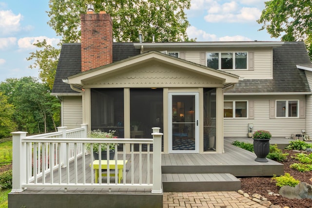 18760 Valencia St, Northville, MI 48168 - back of house with a sunroom, a shingled roof, a wooden deck, and a chimney