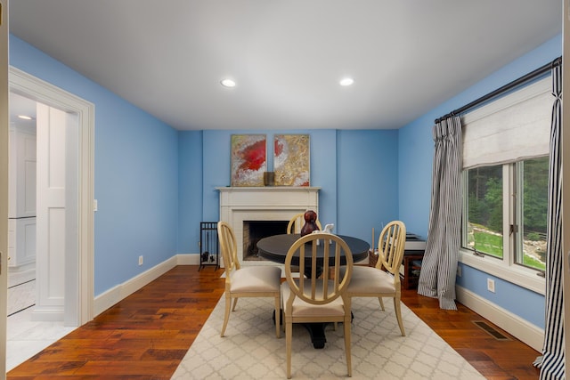 18760 Valencia St, Northville, MI 48168 - dining room featuring wood finished floors, baseboards, a fireplace, and visible vents