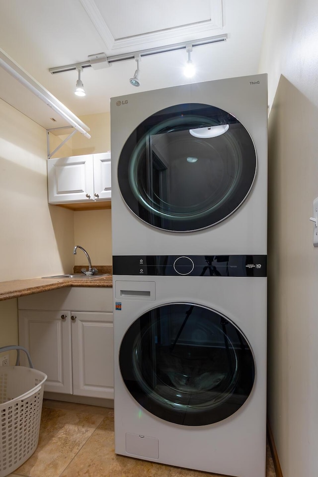 18760 Valencia St, Northville, MI 48168 - clothes washing area with cabinet space, rail lighting, stacked washer / drying machine, and a sink