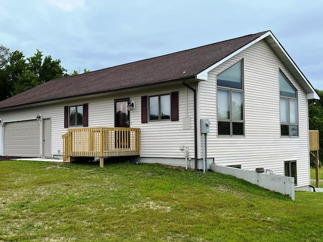 back of property featuring a garage and a yard