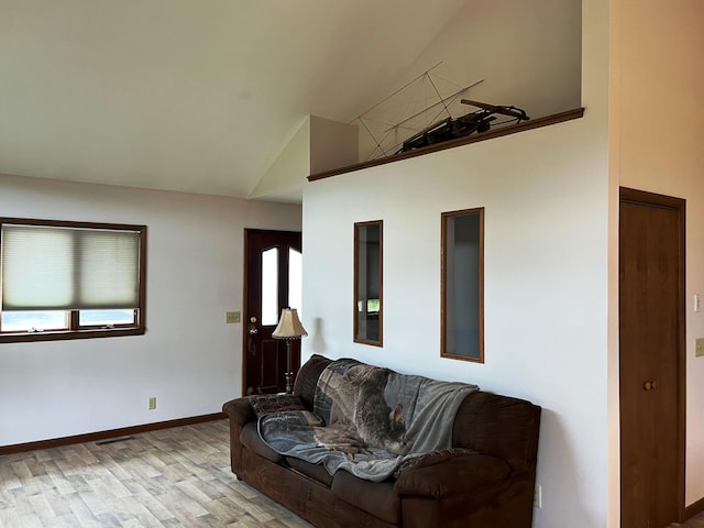 living room with high vaulted ceiling and light wood-type flooring