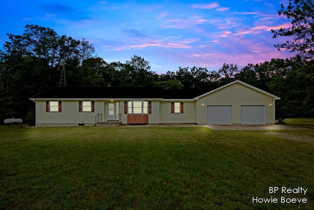 single story home featuring a yard and a garage