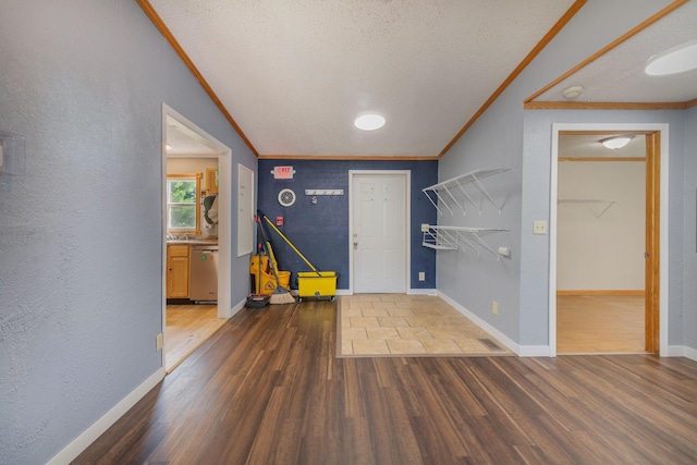 entryway featuring a textured ceiling, ornamental molding, and wood-type flooring