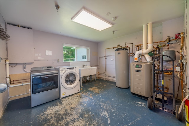 clothes washing area featuring independent washer and dryer, gas water heater, and sink