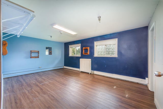 unfurnished living room with a baseboard radiator, radiator, and hardwood / wood-style floors