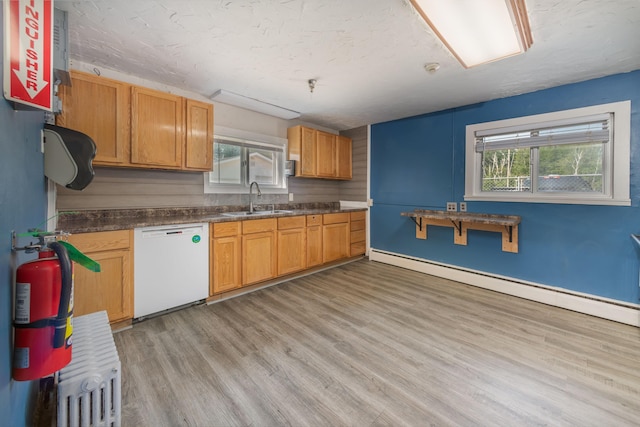 kitchen featuring sink, dishwasher, a baseboard heating unit, and light wood-type flooring