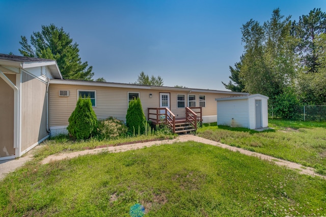 view of front of home with a wooden deck, an outdoor structure, and a front yard