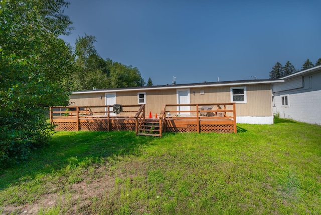 back of property featuring a wooden deck and a yard