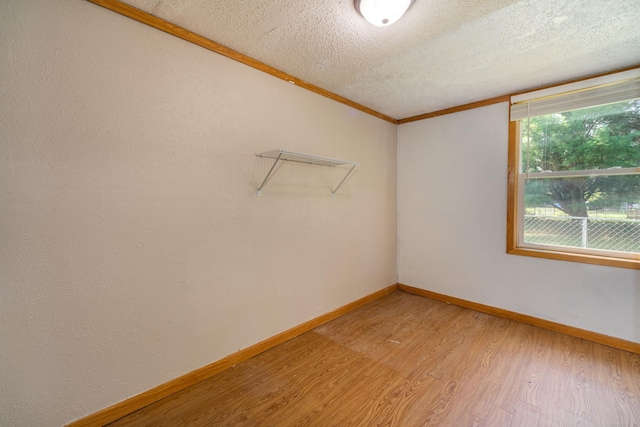 spare room with ornamental molding, a textured ceiling, and hardwood / wood-style flooring