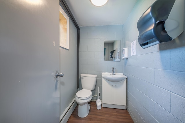 bathroom featuring vanity, toilet, a baseboard heating unit, and hardwood / wood-style floors