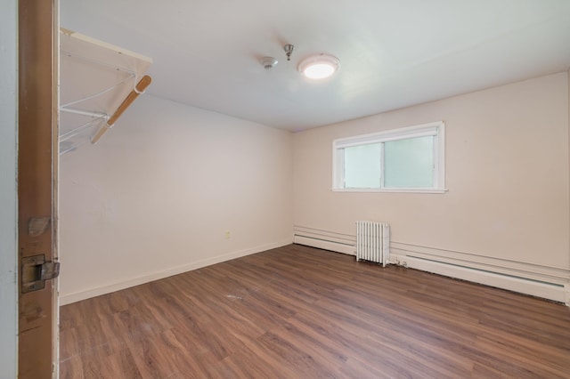 empty room featuring hardwood / wood-style flooring, a baseboard radiator, and radiator heating unit