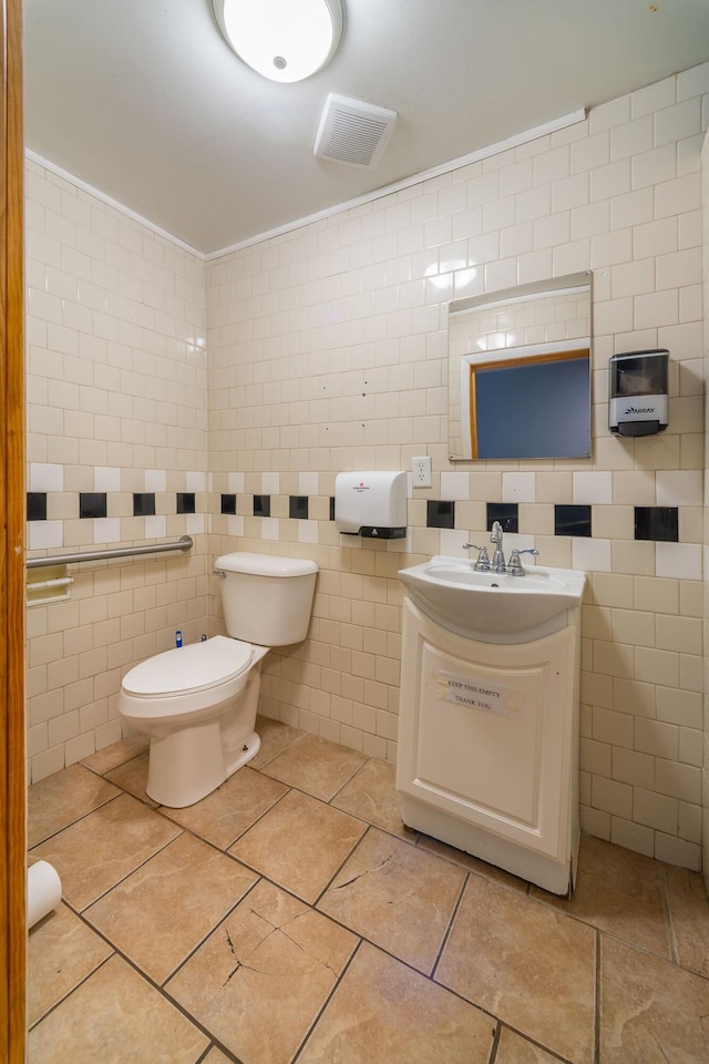 bathroom featuring vanity, tile walls, toilet, and tile patterned flooring