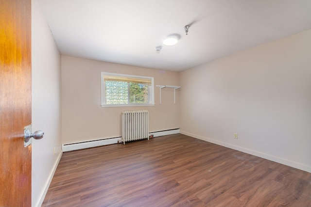 empty room with a baseboard radiator, radiator, and hardwood / wood-style floors