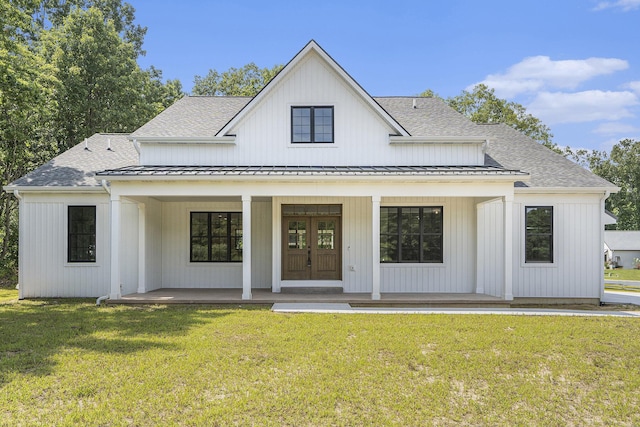 back of house featuring a lawn and covered porch