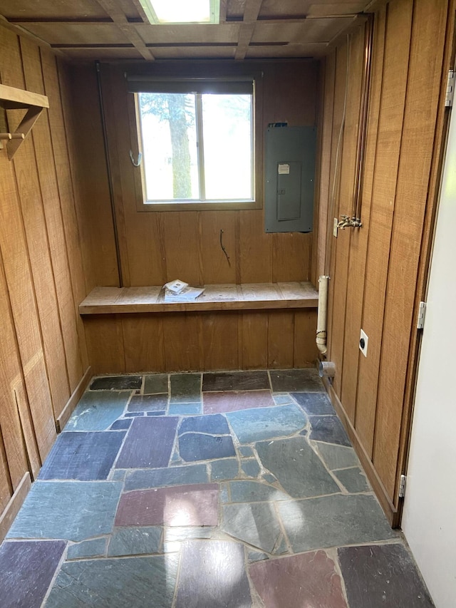 bathroom with electric panel and wood walls