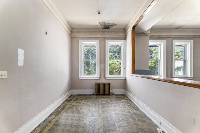 spare room with crown molding and radiator