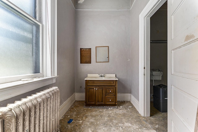 bathroom with radiator heating unit, vanity, and a wealth of natural light