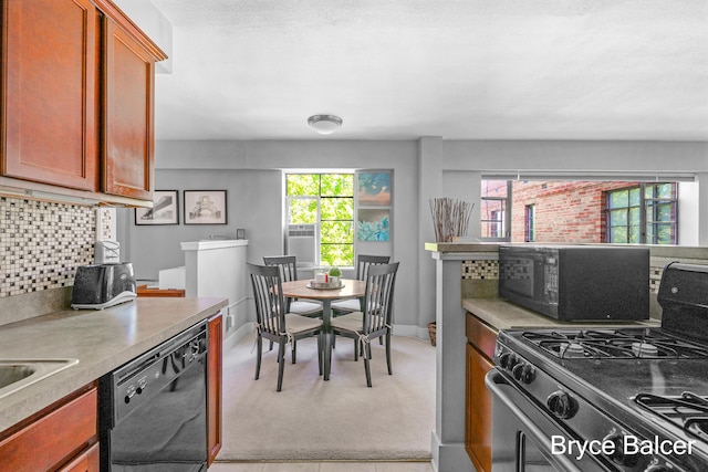 kitchen with tasteful backsplash, light colored carpet, black appliances, and a healthy amount of sunlight