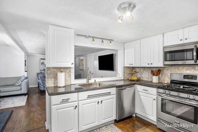 kitchen featuring appliances with stainless steel finishes, sink, decorative backsplash, and white cabinets