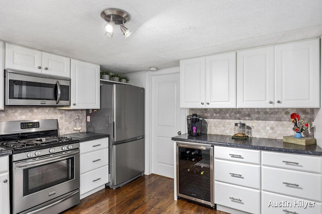 kitchen featuring dark hardwood / wood-style floors, white cabinets, wine cooler, stainless steel appliances, and a textured ceiling