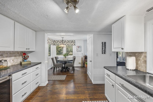 kitchen featuring dark wood-type flooring, beverage cooler, decorative backsplash, and white cabinets