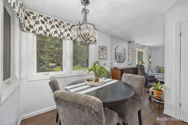 dining area featuring an inviting chandelier, dark hardwood / wood-style floors, and a textured ceiling