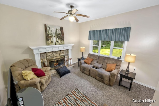 living room featuring a stone fireplace, ceiling fan, and carpet