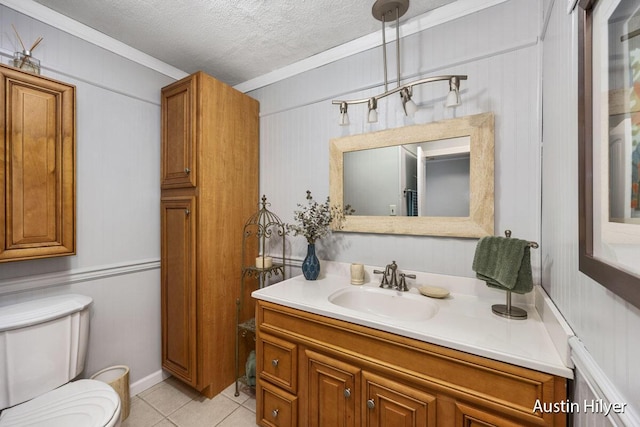 bathroom with vanity, ornamental molding, a textured ceiling, tile patterned floors, and toilet