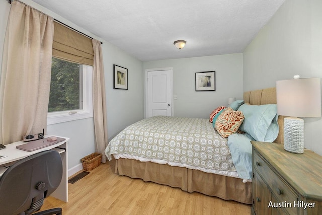 bedroom featuring a textured ceiling and light wood-type flooring