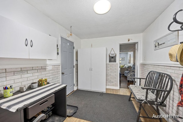 kitchen with white cabinetry, a textured ceiling, and dark colored carpet