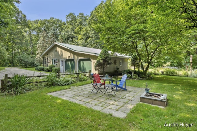 back of house with a yard, a patio area, and an outdoor fire pit