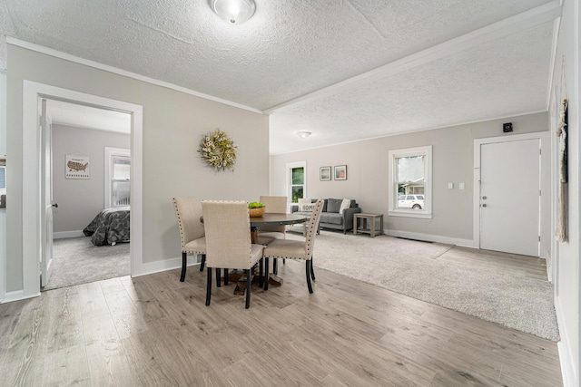 dining area featuring light hardwood / wood-style flooring and a textured ceiling