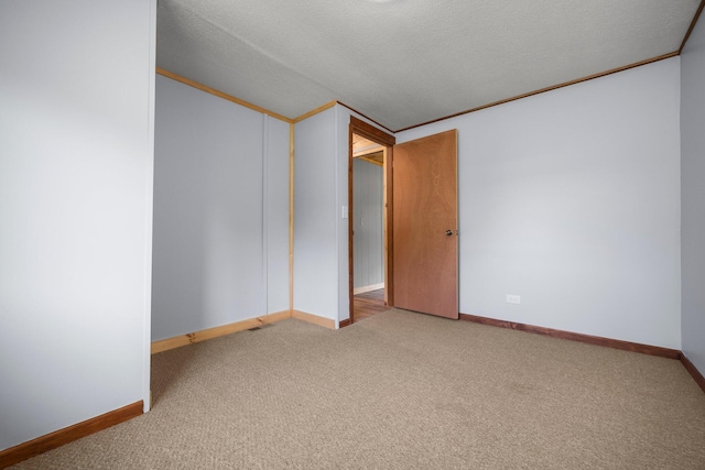 carpeted spare room featuring ornamental molding and a textured ceiling