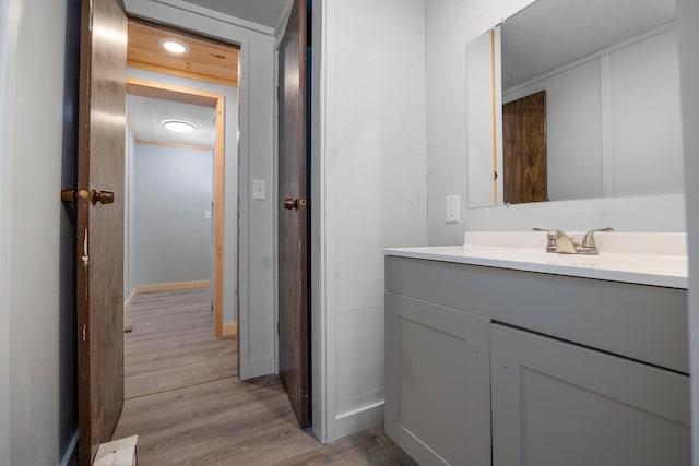 bathroom featuring vanity, hardwood / wood-style floors, and ornamental molding