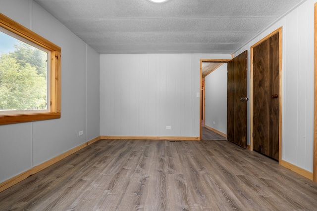 unfurnished room with hardwood / wood-style floors and a textured ceiling