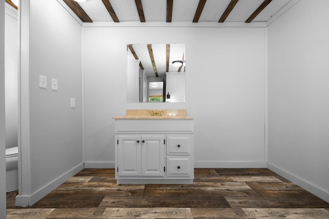 bathroom with vanity, hardwood / wood-style floors, toilet, and beamed ceiling