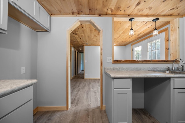 kitchen featuring white cabinetry, sink, hanging light fixtures, wood ceiling, and dark wood-type flooring