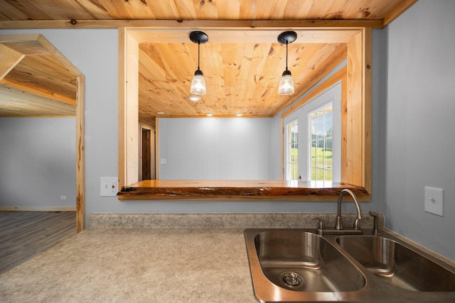 kitchen featuring pendant lighting, wood ceiling, sink, and carpet floors