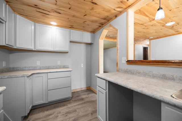 kitchen with decorative light fixtures, wooden ceiling, white cabinets, and light wood-type flooring