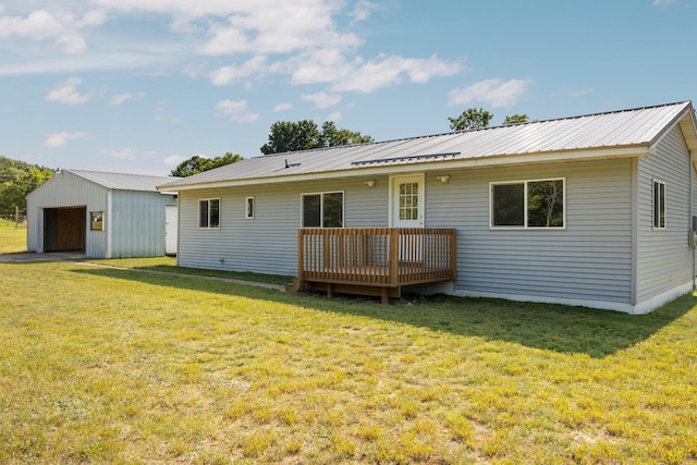 back of house with a wooden deck, a garage, an outdoor structure, and a yard