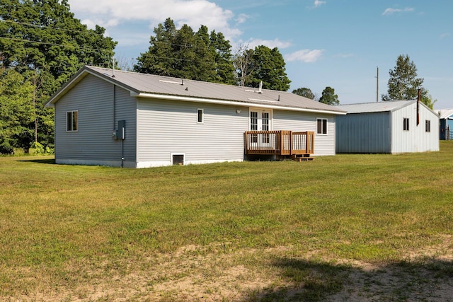 back of property featuring a wooden deck and a lawn