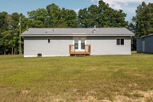 back of house featuring french doors and a lawn