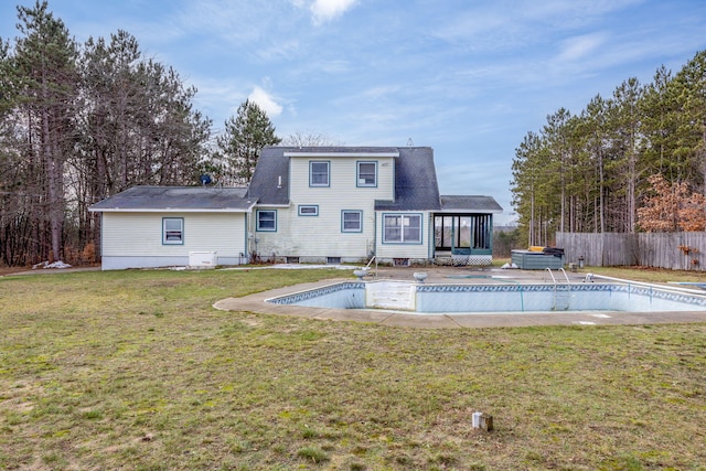 back of property featuring a fenced in pool, a lawn, and a sunroom