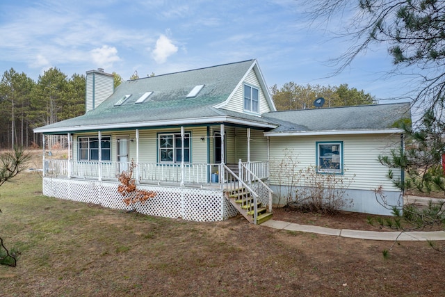 farmhouse featuring a front lawn and a porch