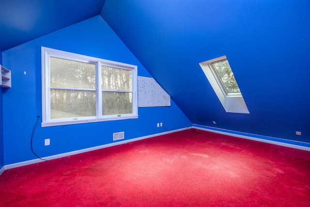 bonus room with carpet flooring and lofted ceiling with skylight